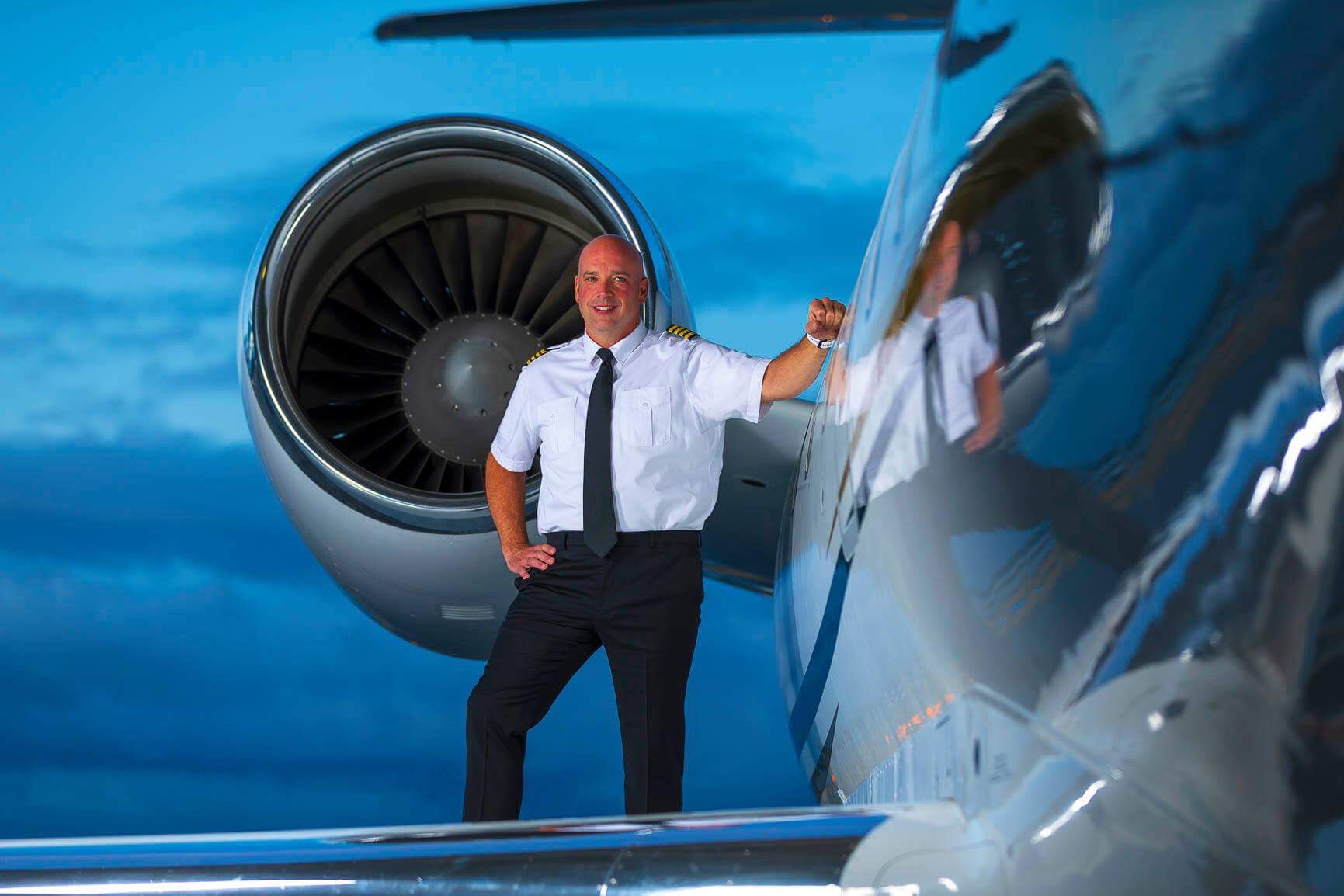 Owen Stacey commercial jet pilot in uniform beside aircraft engine